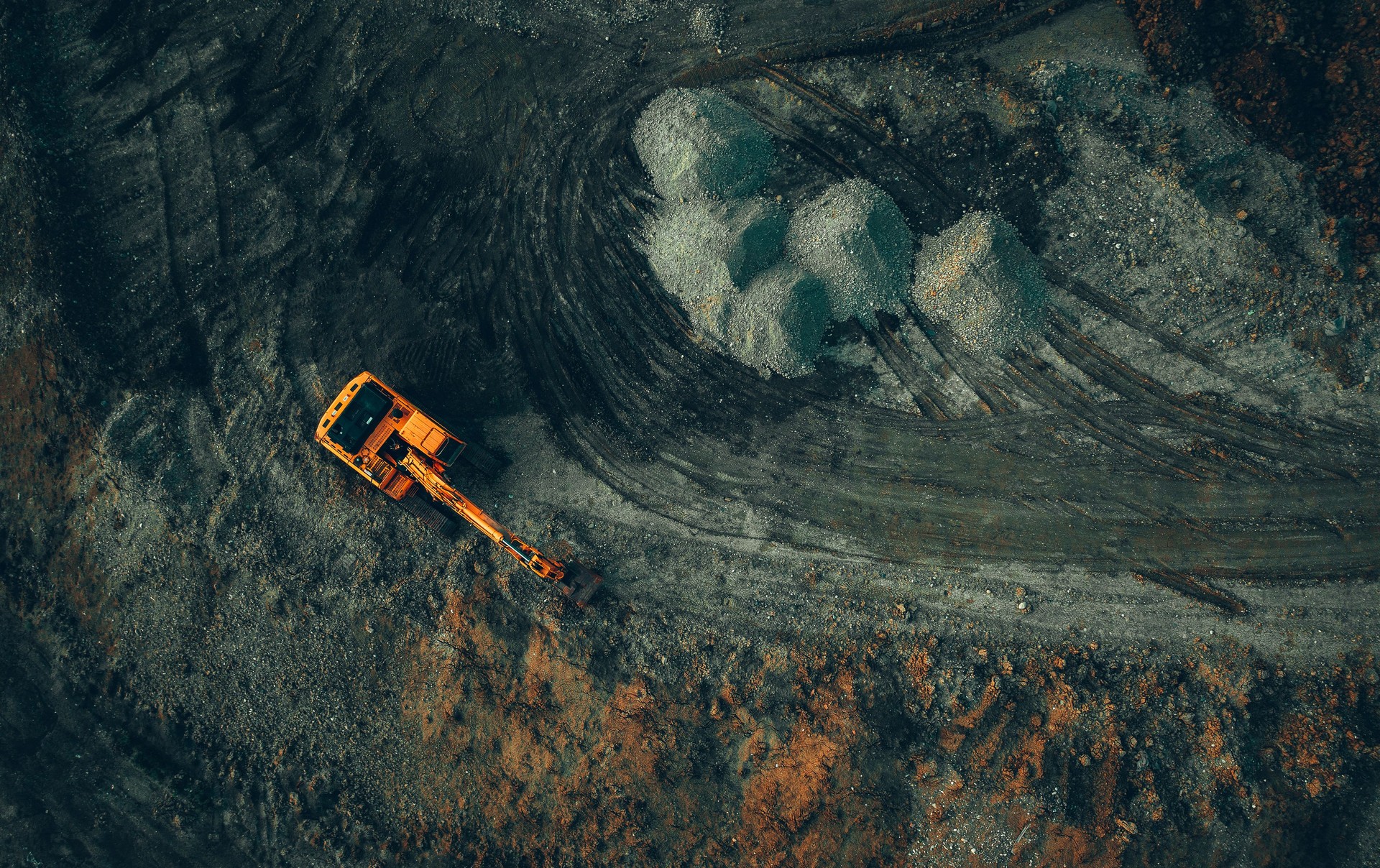 bright excavator at work on a dark background view from a drone